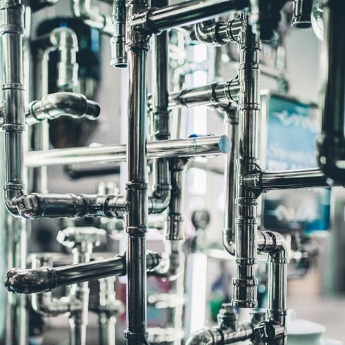 Close-up of complex stainless steel pipes in an industrial setting, showcasing modern engineering.
